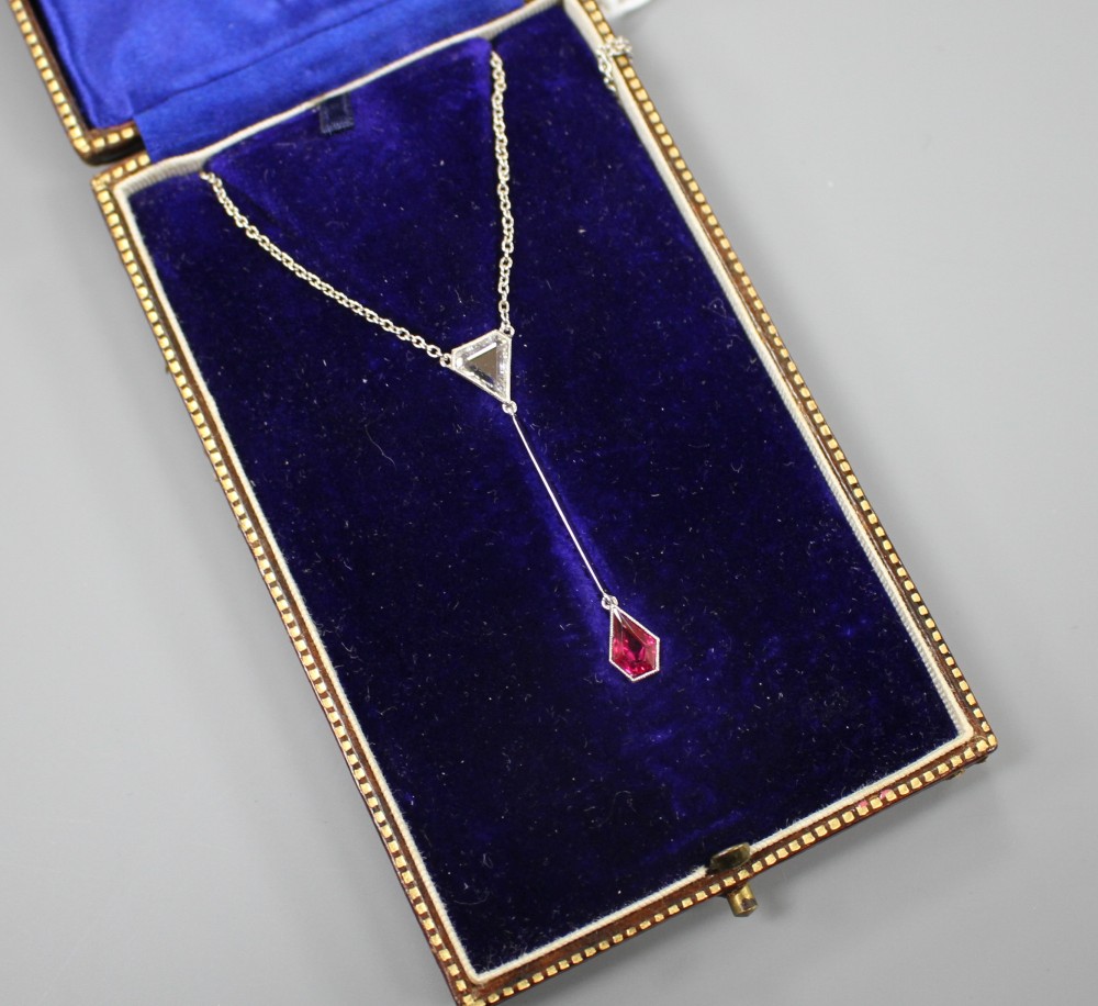 An Art Deco style white metal, ruby and diamond set drop pendant necklace, pendant section 40mm, gross weight 3.9 grams.